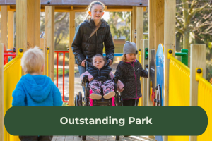A group of children walk across a play fort, one is in a wheelchair